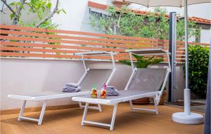 a white bench sitting on a patio with an umbrella at Cozy Home In Klimno With Wifi in Klimno +27 photos