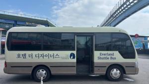 a white bus parked in front of a bridge at Hotel The Designers Incheon in Incheon