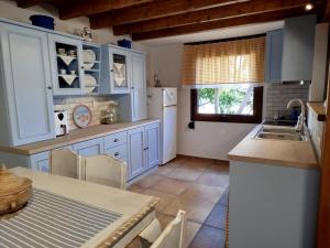 a kitchen with blue cabinets and a table and a sink at dilemi 3 in Tavari
