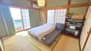a bedroom with a bed in a room with windows at AsahiStay -Koiwa, Free parking O, Whole Family House, Japanese garden taste in Tokyo