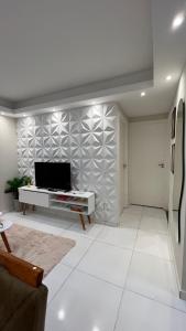 a living room with a tv on a wall at Apartamento Térreo Completo! Com Ótima Localização in Fortaleza
