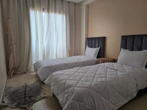ein Hotelzimmer mit zwei Betten und einem Fenster in der Unterkunft Appartement Moderne Gueliz in Marrakesch
