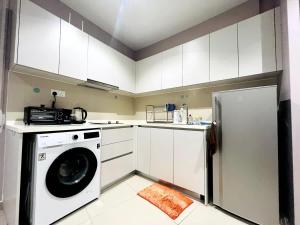 a kitchen with a washing machine and a refrigerator at Diva Homes at i-City WiFi TV Box and 1 Carpark in Shah Alam