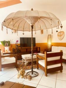 a living room with a large umbrella in the middle at Villa Baobá Pousada & Spa in Búzios