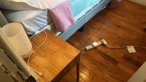 a bed with a wooden table next to a wooden floor at 2218NColoradoC in Philadelphia