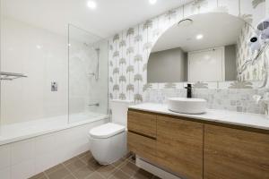 un bagno con lavandino, WC e vasca di Artique Surfers Paradise - Official a Gold Coast