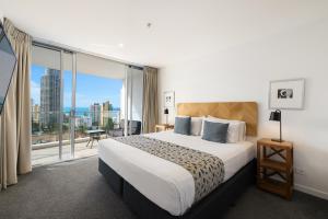 una camera d'albergo con un letto e una grande finestra di Artique Surfers Paradise - Official a Gold Coast