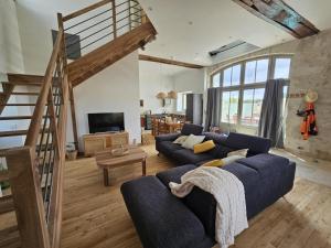 un soggiorno con un divano blu e una scala di Charmant Gîte 6 Pers avec Piscine Privée et Jardin, Avon-les-Roches - FR-1-381-629 a Avon-les-Roches