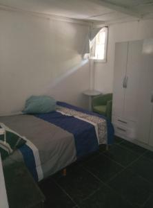 - une chambre avec un lit et une chaise verte dans l'établissement Finca de montaña agua Gracian, à Pomancillo