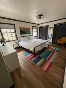 a bedroom with a bed and a colorful rug at Modern Mountainside Cabin in Bella Vista