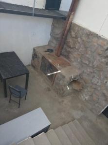 Cette chambre dispose d'une table et d'un mur en pierre. dans l'établissement Finca de montaña agua Gracian, à Pomancillo