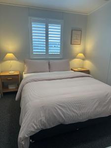 ロックハンプトンにあるWandal Loft Apartmentの大きな白いベッドと2つのランプのある寝室