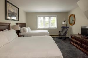 Una habitación de hotel con dos camas y un televisor. en Rocky Crest Golf Resort, en MacTier 82 fotos más