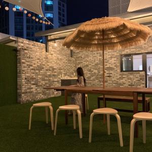 a woman sitting at a table with an umbrella at No 25 Hotel Dongseongro branch in Daegu +57 photos
