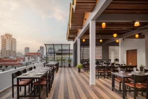 a restaurant with tables and chairs on a balcony at Queen Mansion in Phnom Penh