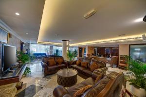 a living room with leather couches and a tv at Ajman Beach Hotel in Ajman 