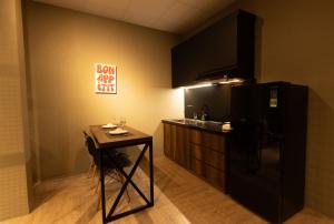 a kitchen with a small table and a black refrigerator at Midas Home in Da Lat