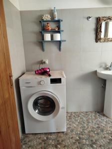 a washing machine in a bathroom with a sink at dilemi 3 in Tavari