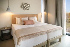 una camera da letto con un grande letto bianco con una finestra di Amazing Protaras Villa Villa Lubbock 3 Bedrooms Private Outdoor Pool a Protaras Altre 32 foto