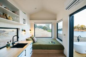 a tiny house with a bed and a large window at Tiny Matilda in Bridgetown