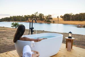 a woman in a bath tub with a glass of wine at Tiny Matilda in Bridgetown