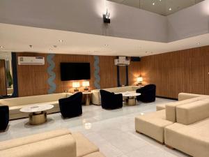 a lobby with couches and tables and a flat screen tv at فندق فيوري - المطار in Taif