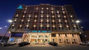 a tall building with cars parked in front of it at فندق فيوري - المطار in Taif