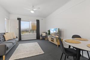 グレネルグにあるBeachside 2-Bed Apartment with Balcony Viewsのソファとテーブルのあるリビングルーム