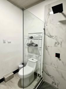 a bathroom with a toilet and a glass shower stall at Paraiso En-suite #3 in Parrita