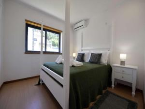 ein Schlafzimmer mit einem grünen Bett und einem Fenster in der Unterkunft Charming Caminha Villa 4 Bedrooms Villa Caminha View Private Pool in Caminha + 22 Fotos