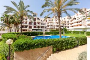 un complexe d'appartements avec piscine et palmiers dans l'établissement Apartamento increible Playazo Vera, à Vera