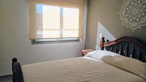 een slaapkamer met een bed en een raam bij Exelente departamento en Carlos Paz in Villa Carlos Paz +7 foto's