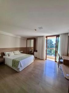una grande camera da letto con un letto e una grande finestra di Condominio Vista azul Flat-Hotel a Pedra Azul