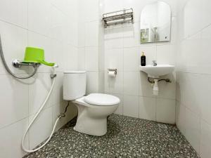un baño con inodoro y lavabo en Hotel Permai Syariah RedPartner Sananwetan Blitar, en Karangtengah 79 fotos más