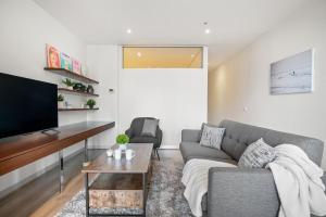 a living room with a couch and a tv at Modern 2B2B Apt near Crown with Parking and City Views in Melbourne