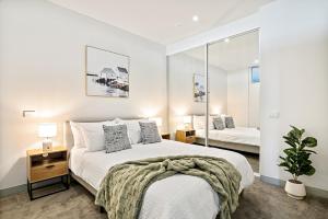 a bedroom with a large bed and a mirror at Modern 2B2B Apt near Crown with Parking and City Views in Melbourne