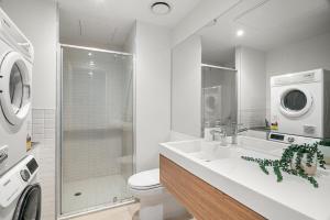 a bathroom with a sink and a washing machine at Modern 2B2B Apt near Crown with Parking and City Views in Melbourne +2 photos