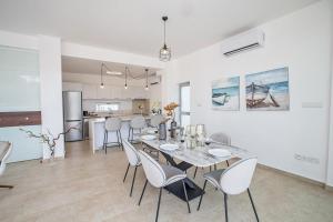 ein Esszimmer und eine Küche mit Tisch und Stühlen in der Unterkunft Villa Olive Thalassa, Brand New, Luxury 3Bdr Protaras Villa With Private Pool in Protaras
