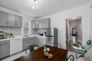 una cucina con mobili bianchi, tavolo e sedie di Heart Of Niagara Falls Stylish a Niagara Falls