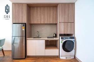 a kitchen with a refrigerator and a washing machine at À La Carte Homestay By Sol Travel in Kon Rung (1)