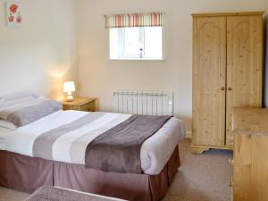 ein Schlafzimmer mit großem Bett und Fenster in der Unterkunft Bluebell Cottage in Wootton Fitzpaine