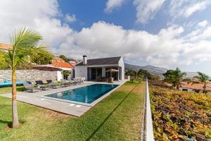 a villa with a swimming pool and a house at Luxury Calheta Villa Casa Calheta Heights 3 Bedrooms Stunning Sea Views in Calheta