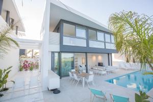 ein Haus mit einem Pool, einem Tisch und Stühlen in der Unterkunft Villa Limni Enas - Luxury And Contemporary 3 Bedroom Kapparis Villa With Sea View in Paralimni