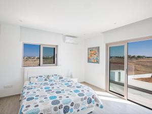 ein weißes Schlafzimmer mit einem Bett und einigen Fenstern in der Unterkunft Villa Ioanni Chrysos - Luxury And New 6 Bedroom Protaras Villa in Protaras + 18 Fotos