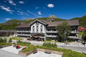 a large white building with mountains in the background at Skogstad Hotel in Hemsedal