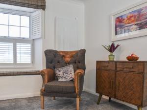 silla con almohada en una habitación con tocador en Bryn Y Felin, en Dyffryn