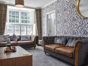 una sala de estar con un sofá y una mesa en Bryn Y Felin, en Dyffryn