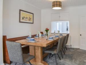 Un comedor con mesa y sillas de madera. en Bryn Y Felin, en Dyffryn