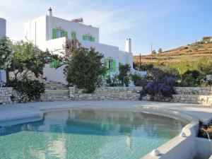 a swimming pool in front of a white house at Villa Armonia in Piso Livadi