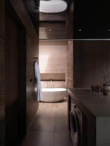 a bathroom with a tub and a washing machine at The Moor in Busan +20 photos
